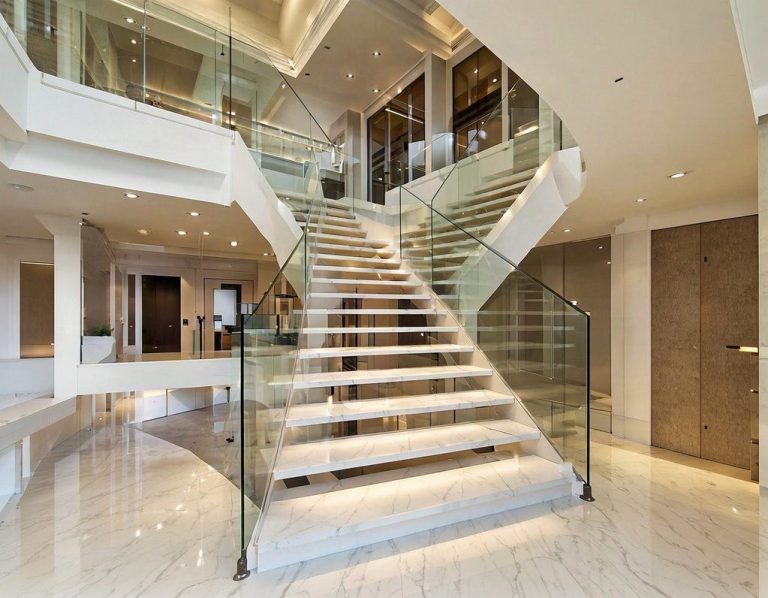 Two-story marble staircase with glass railing