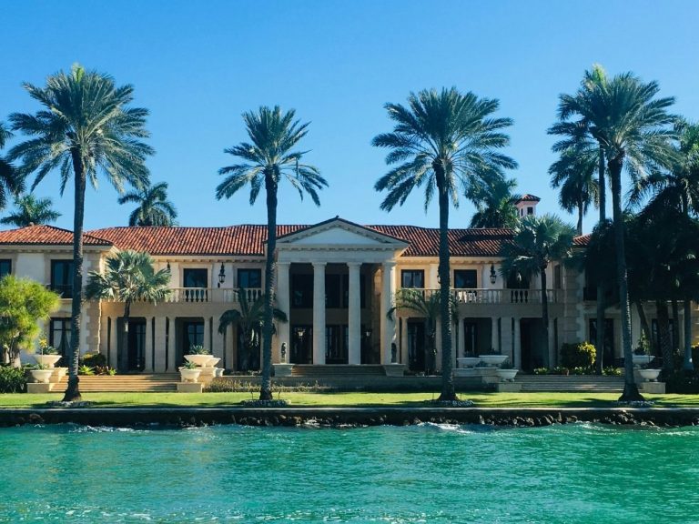 Florida Bayfront home with views of the water and landscaped yard with trees