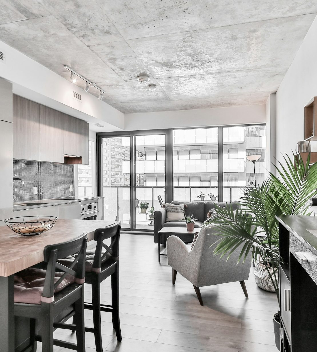 Modern kitchen and dining area with seating and balcony